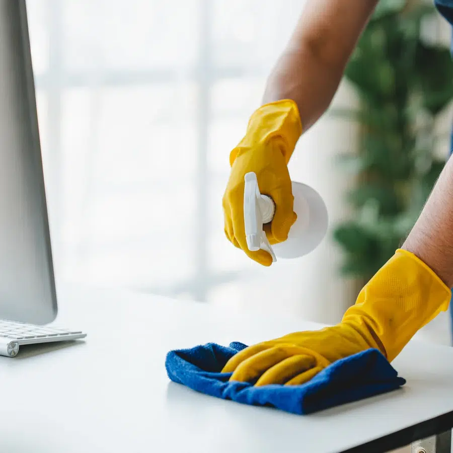 Nettoyage de bureau avec gants et chiffon